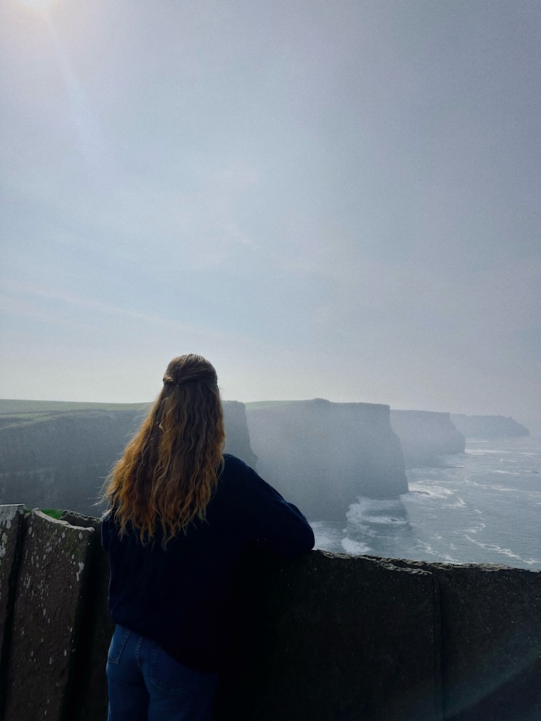 Kendyll looking out at dramatic coastal cliffs above the ocean